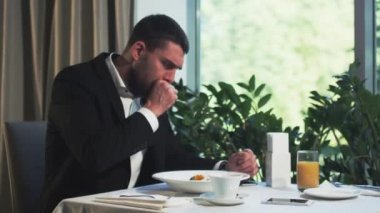 Бизнесмен кашляет и использует салфетку в ресторане — стоковое видео