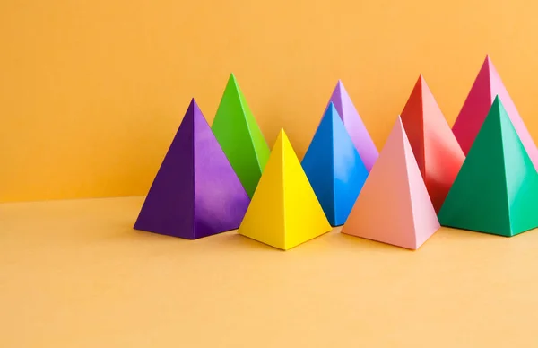 Красочные геометрического абстрактного натюрморт композиции. Яркие Призма пирамиды треугольник форму фигуры. Справочный документ объекты, оранжевый фиолетовый желтый синий розовый зеленый красный цвет — стоковое фото