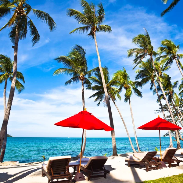 Красный зонтики и стулья на песок пляж i — стоковое фото