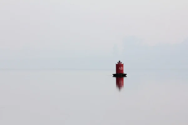 Красный буй на реке в тумане — стоковое фото