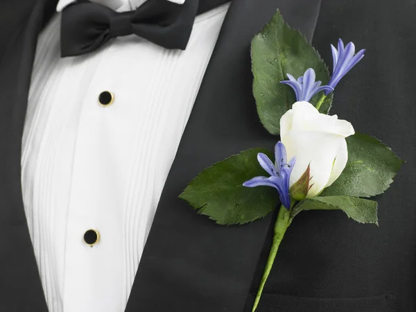 Человек, одетый В костюм с белой розы корсаж — стоковое фото