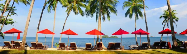 Панорама идеальный тропический пляж с красными зонтами — стоковое фото