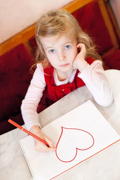 Маленькая девочка рисует сердце. День Святого Валентина — стоковое фото