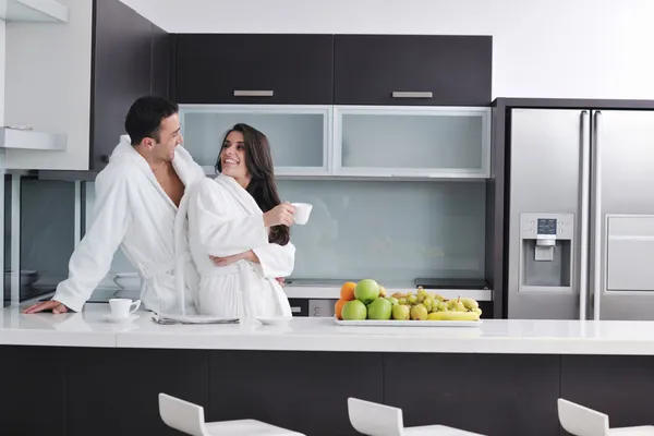 Счастливая пара, читая газету на кухне на завтрак — стоковое фото