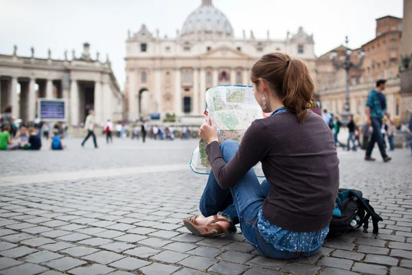 Симпатичный молодой турист женского пола, изучающий карту на площади peter's Св. — стоковое фото