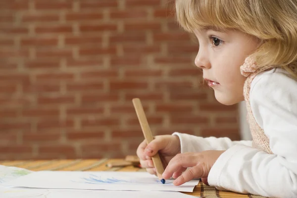 Маленькая девочка рисует на бумаге — стоковое фото