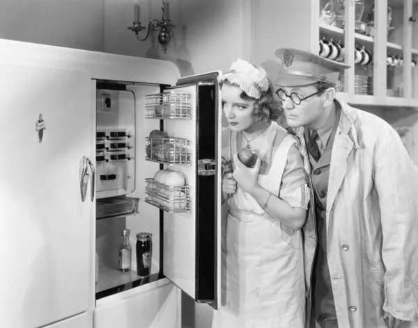 Мужчина и женщина стоять перед холодильником — стоковое фото