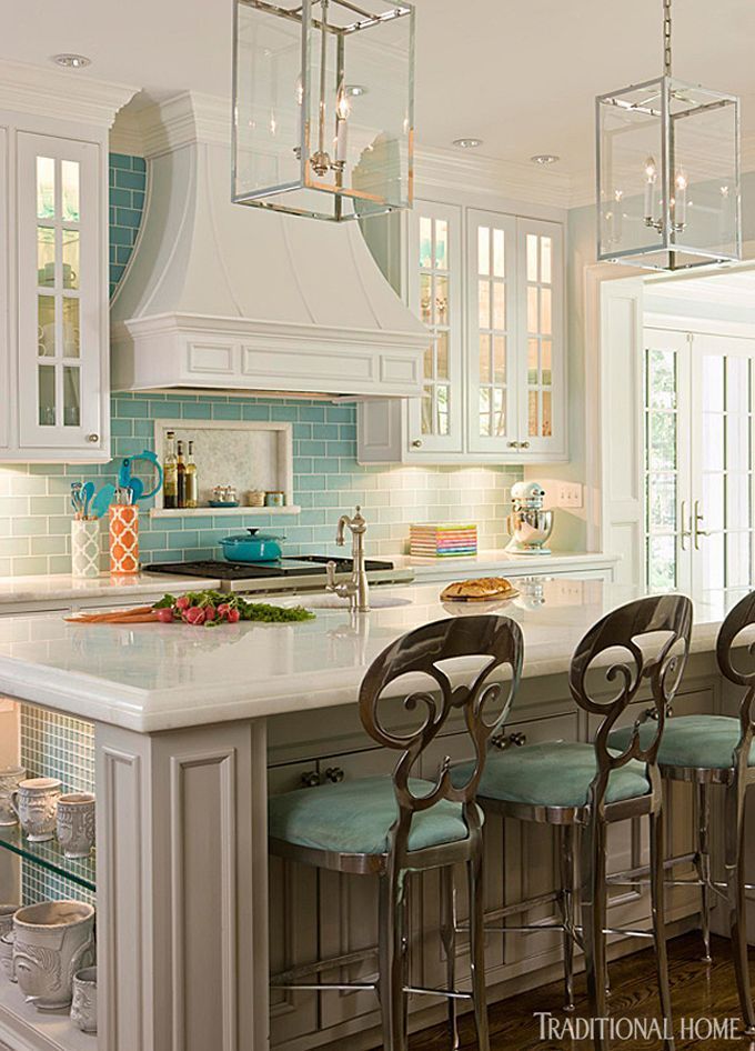 The kitchen’s elegant but not overdone white cabinetry teams with pale turquoise tiles. - Traditional Home ® / Photo: Gordon Beall / Design: Kat Liebschwager