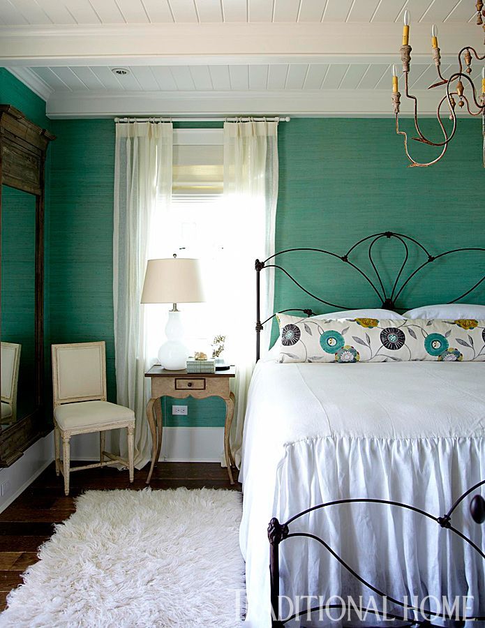 Wallpaper from Osborne & Little shrouds the room in a lovely turquoise hue—a color repeated on the floral accent pillow.