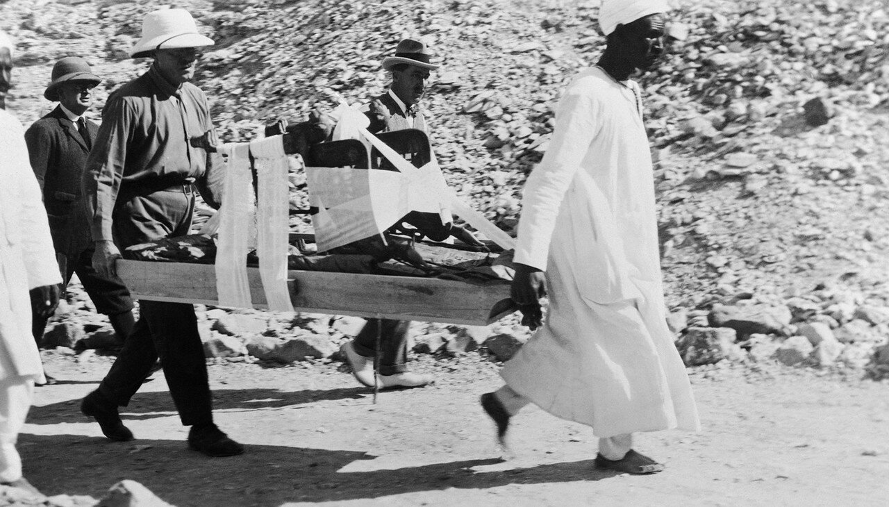 Говард Картер смотрит, как носильщики несут трон из гробницы Тутанхамона. 1923