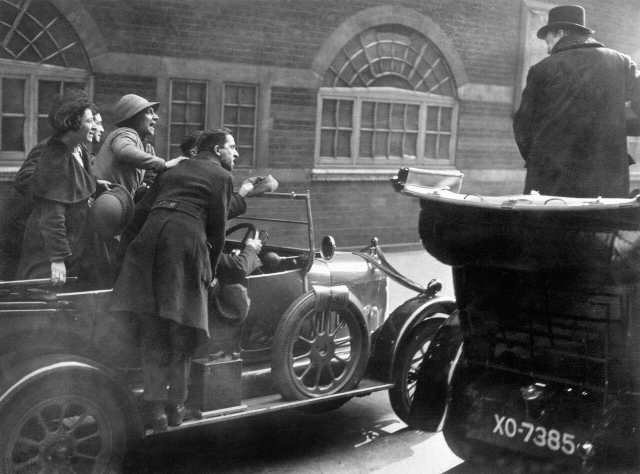 1924. Уинстон Черчилль, крайний справа, стоит в машине под градом насмешек преследовавших его социалистов после поражения на выборах