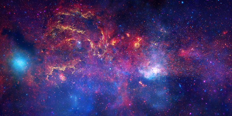 In celebration of the International Year of Astronomy 2009, the NASA/ESA Hubble Space Telescope and its companion Great Observatories: the Spitzer Space Telescope and the Chandra X-ray Observatory have collaborated to produce an unprecedented image of the central region of our Milky Way galaxy. In this spectacular image, observations using infrared light and X-ray light see through the obscuring dust and reveal the intense activity near the galactic core. Note that the centre of the galaxy is located within the bright white region to the right of and just below the middle of the image. The entire image width covers about one-half a degree, about the same angular width as the full moon. Each telescope's contribution is presented in a different colour: Yellow represents the near-infrared observations of Hubble. They outline the energetic regions where stars are being born as well as reveal hundreds of thousands of stars. Red represents the infrared observations of Spitzer. The radiation and winds from stars create glowing dust clouds that exhibit complex structures from compact, spherical globules to long, stringy filaments. Blue and violet represent the X-ray observations of Chandra. X-rays are emitted by gas heated to millions of degrees by stellar explosions and by outflows from the supermassive black hole in the galaxy's centre. The bright blue blob on the left side is emission from a double star system containing either a neutron star or a black hole. When these views are brought together, this composite image provides one of the most detailed views ever of our galaxy's mysterious core.