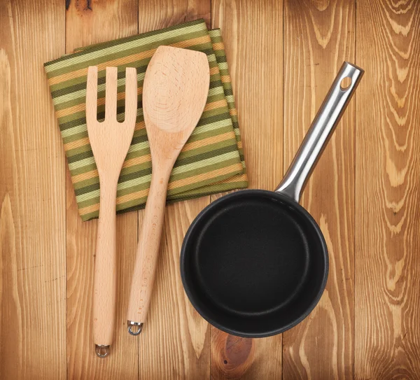 Сковороды и посуда на деревянный стол — стоковое фото