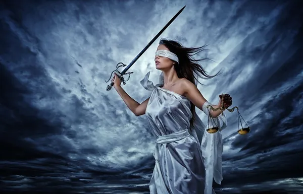 Фемида, богиня справедливости, с весами и мечом носить с завязанными глазами против драматических грозовое небо — стоковое фото