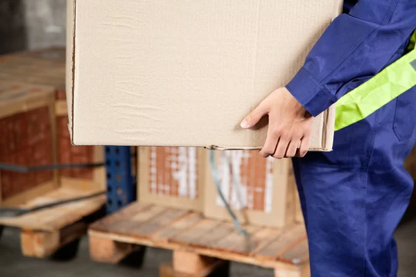 Форман, перевозящих картонную коробку на складе — стоковое фото