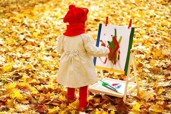 Ребенок, опираясь на мольберте в желтый Осенний парк. Творческие дети — стоковое фото