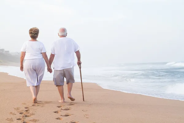 Пожилые супружеские пары рука об руку ходить — стоковое фото