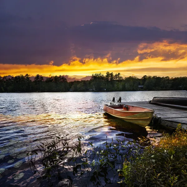 Лодка, закрепленной на озеро на закате — стоковое фото
