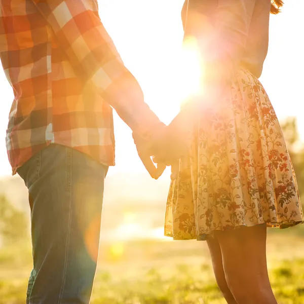 Молодая пара в любви в осенние парке, взявшись за руки — стоковое фото