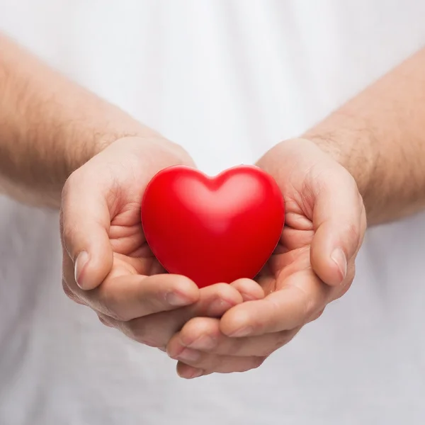 Ман чашевидный руки показаны красное сердце — стоковое фото