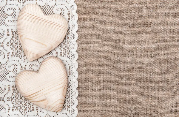 Фон мешковины с кружевной ткани и деревянные сердца — стоковое фото