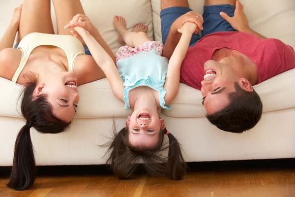 Семья вниз лежал на диване с дочерью — стоковое фото