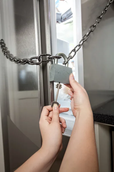 Женщина открыть замок на холодильник с большой ключ — стоковое фото