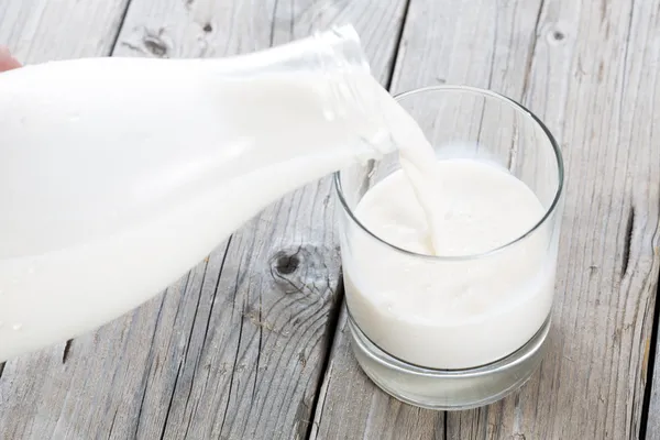 Бутылка и стакан молока — стоковое фото