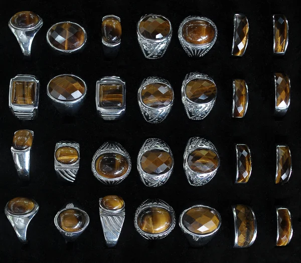 Серебряные кольца и коричневый Джейд на черный Backbround — стоковое фото