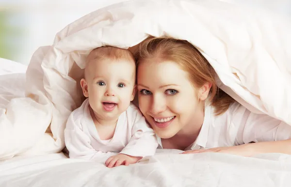 Счастливая семья. мать и ребенок, играющий под одеялом — стоковое фото