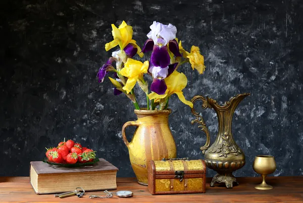 Ирисы в керамической вазе и свежей клубникой — стоковое фото