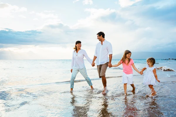 Счастливая семья весело ходить на пляж на закате — стоковое фото