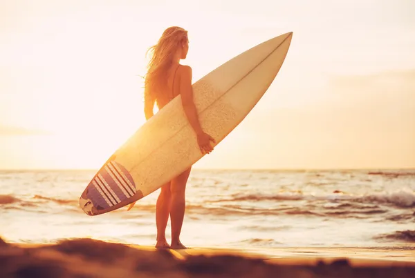 Серфер девочка на пляже на закате — стоковое фото