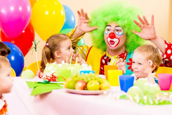 Счастливые дети с клоуном на день рождения — стоковое фото
