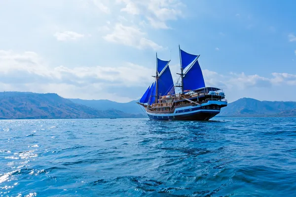 Старинный деревянный корабль с синий паруса — стоковое фото