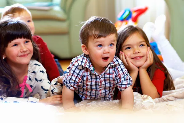 Группа счастливых детей, смотрящих телевизор дома — стоковое фото