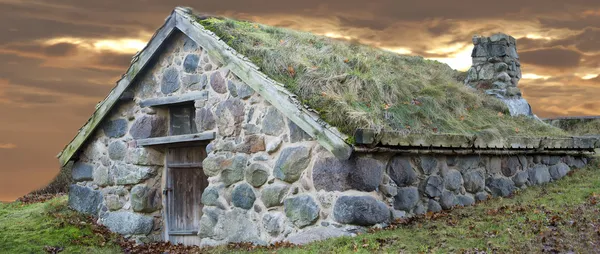 Каменный домик с травой крышей — стоковое фото