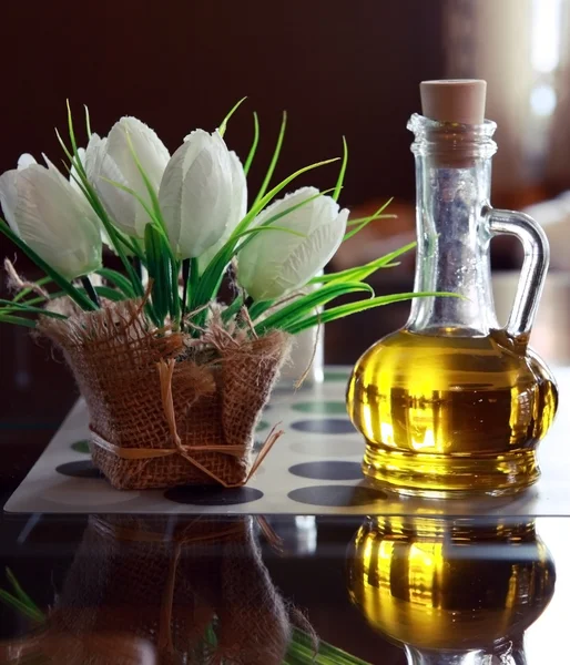 Бутылки оливкового масла и цветы на столе в итальянское кафе — стоковое фото