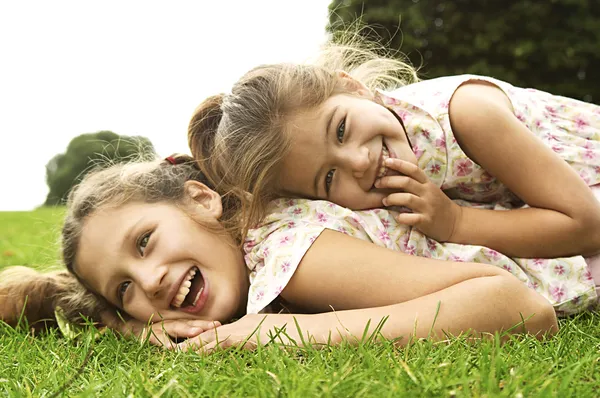 Две сестры, смеяться и играть в парке — стоковое фото
