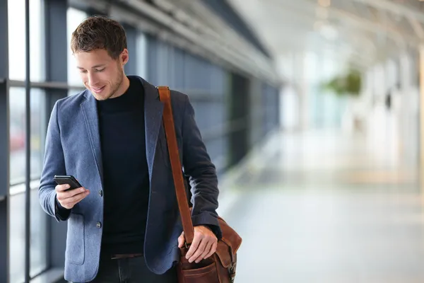 Человек на смартфоне - деловой человек в аэропорту — стоковое фото