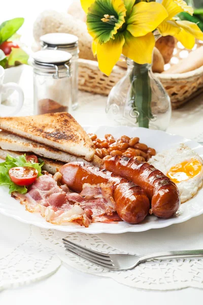 Полный английский завтрак с беконом, колбасы, жареное яйцо и запеченная — стоковое фото