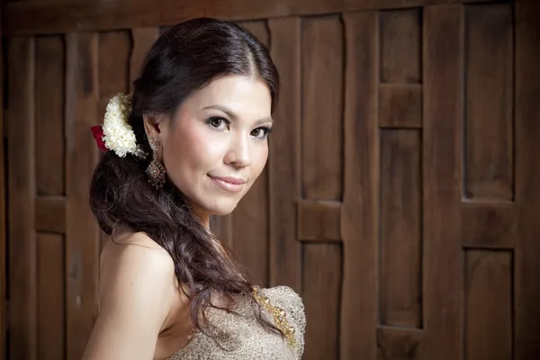 Портрет великолепные азиатских женщина в тайский платье у деревянной стены — стоковое фото