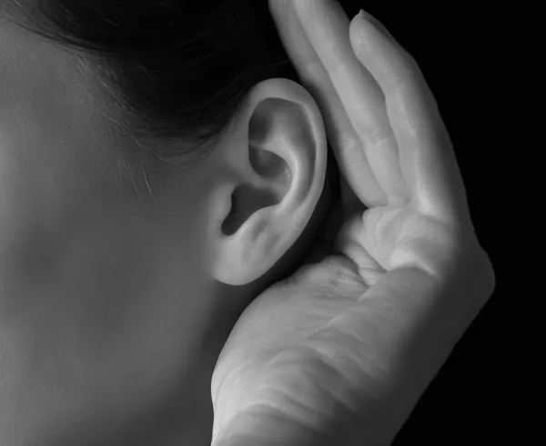 Женщина держит ее руку возле уха — стоковое фото