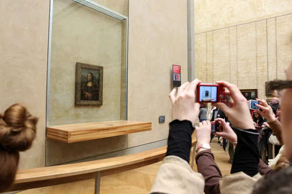 Париж - 3 мая: посетителей принять фото Леонардо да Винчи «Мона Лиза» в Лувре Лицензионные Стоковые Фото