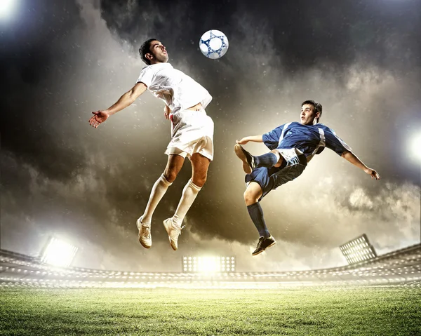 Два футболиста, ударяющие шар Стоковое Фото