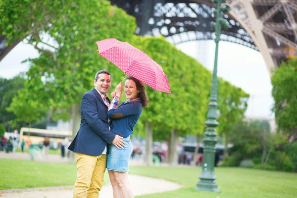 Пара под красный зонт в Париже — стоковое фото