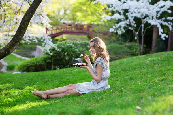 Женщина ест суши в парке — стоковое фото
