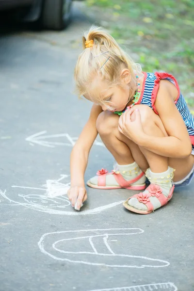 Маленькая девочка рисует мелом — стоковое фото