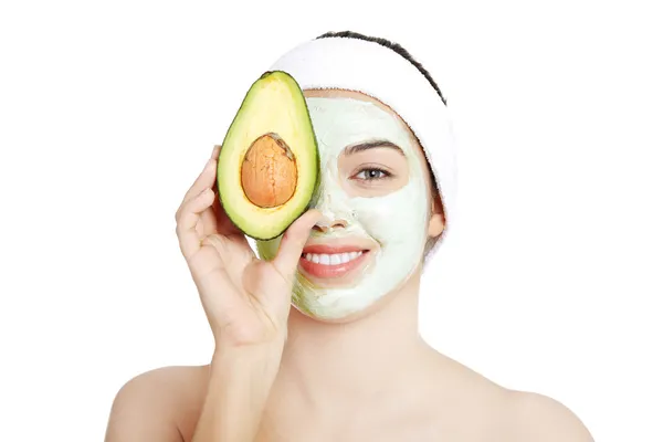 Молодая женщина с улыбкой холдинг с авокадо Лицензионные Стоковые Фото