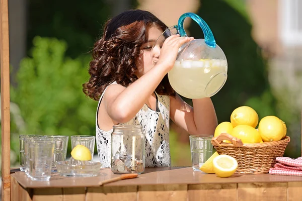 Маленькая девочка, пить из Кувшин лимонада — стоковое фото
